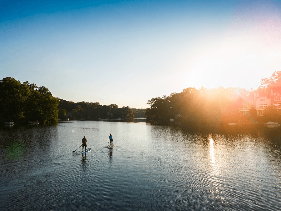 Paddleboarders on the river at sunset